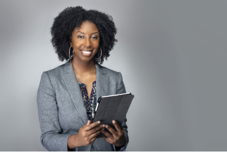Image of a woman in professional suit holding a tablet